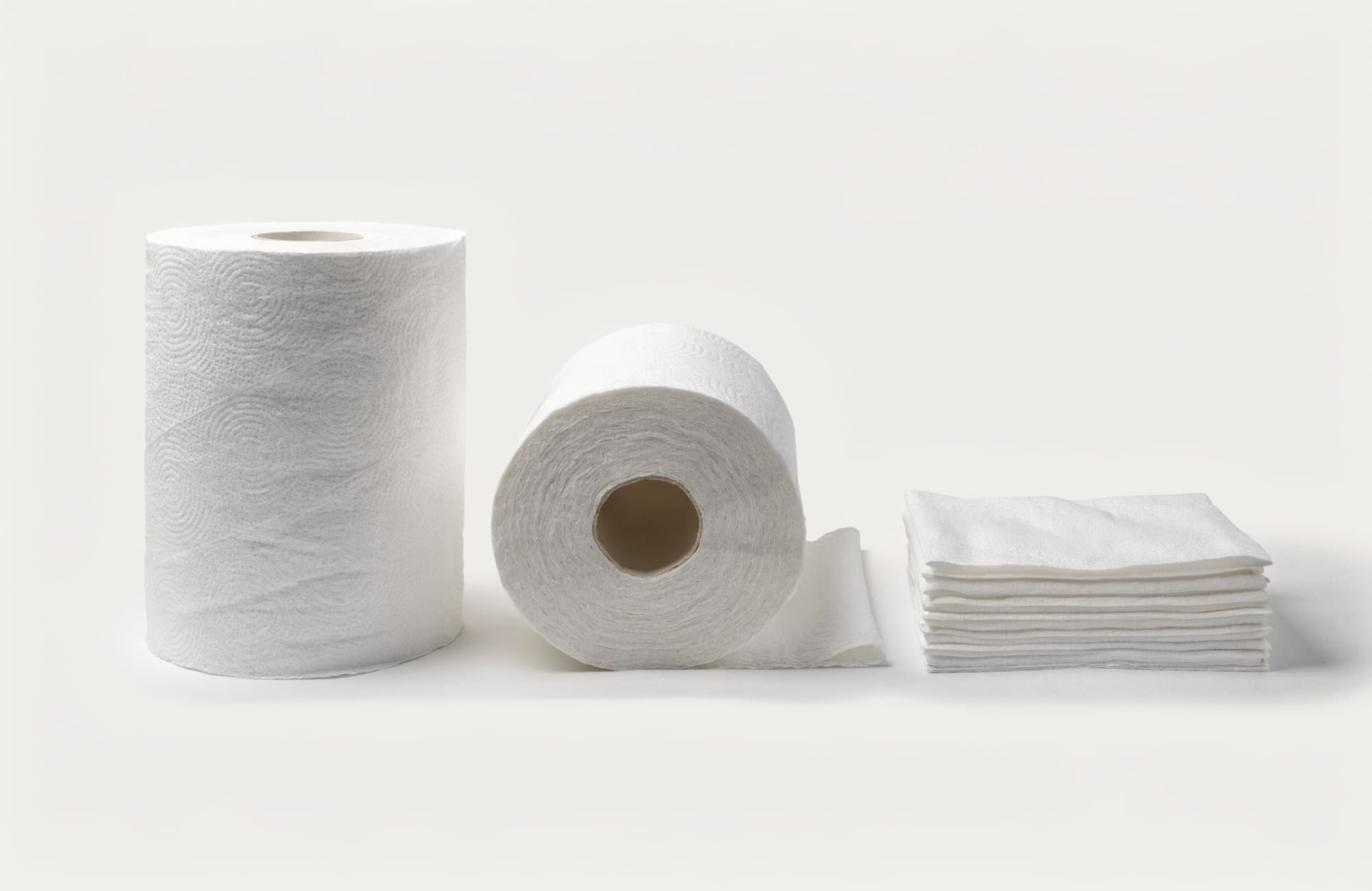 Commercial kitchen paper towel rolls beside folded kitchen tissue
